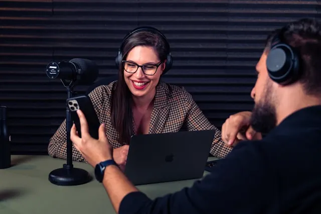 Due persone registrano un podcast con microfoni in studio